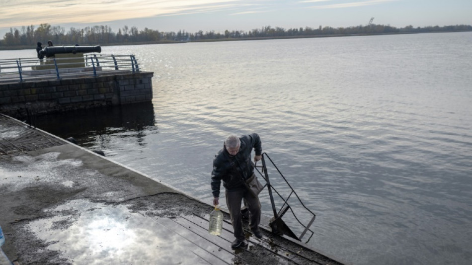 A orillas del río Dniéper en Jersón, ucranianos consiguen agua y telefonía móvil